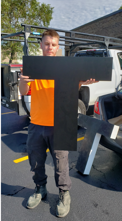 Worker holds the new letter T