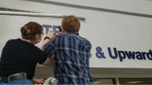 installing the dimensional sign for the university - Sign Artist