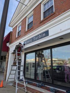 Sign Artist Installing retail signage 